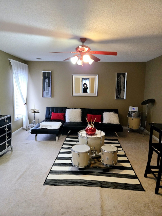 carpeted living room featuring a textured ceiling, baseboards, and a ceiling fan