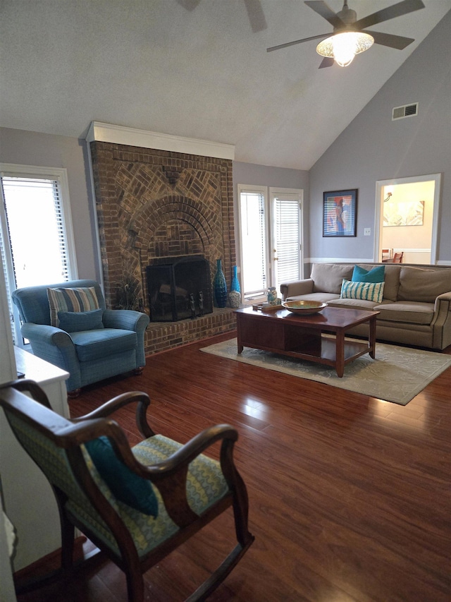 living room featuring a ceiling fan, a healthy amount of sunlight, visible vents, wood finished floors, and a fireplace