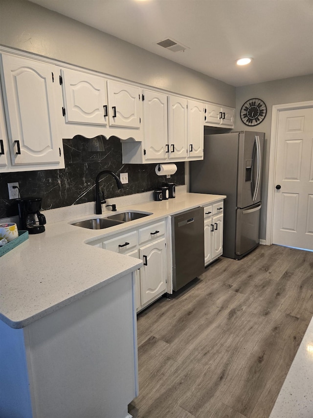 kitchen featuring stainless steel appliances, white cabinets, and a sink