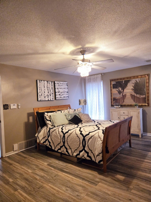 bedroom with baseboards, dark wood-style floors, a ceiling fan, and a textured ceiling