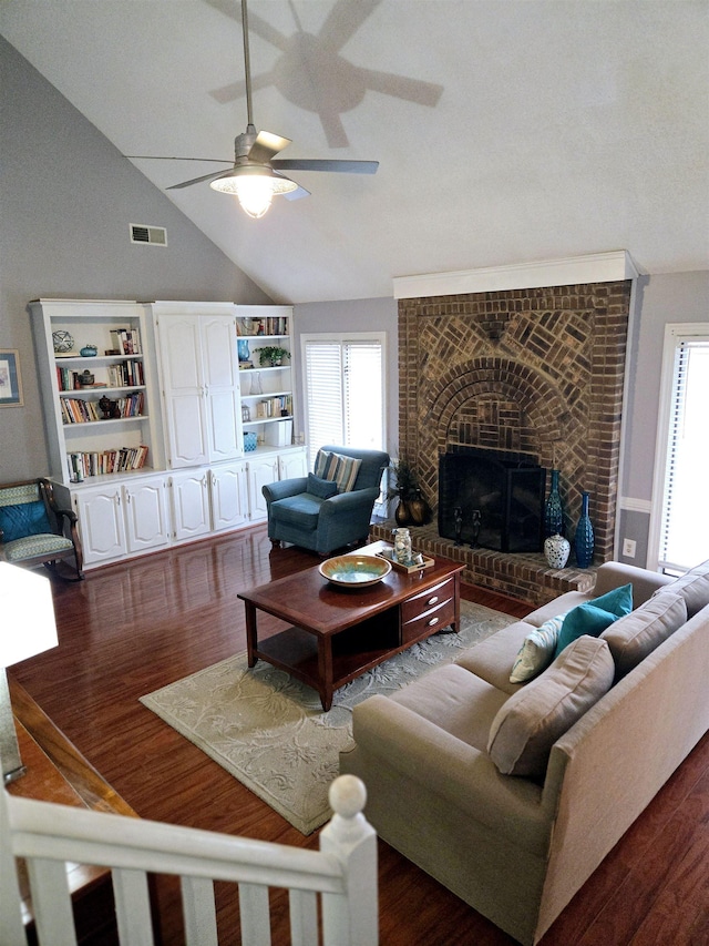 living room with visible vents, dark wood-style flooring, a ceiling fan, and a healthy amount of sunlight