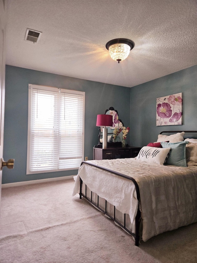 bedroom with carpet, a textured ceiling, and visible vents