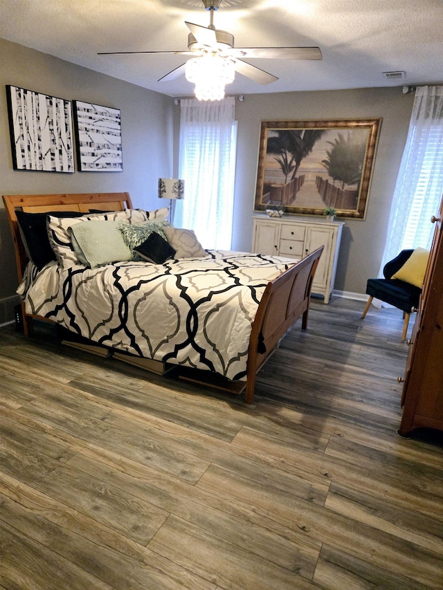 bedroom featuring multiple windows, visible vents, and dark wood-type flooring