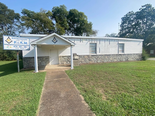 view of front facade with a front yard and stone siding