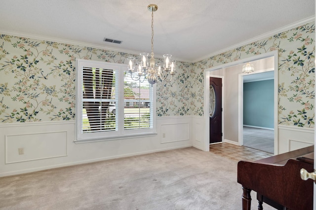 unfurnished dining area with ornamental molding, a chandelier, a wainscoted wall, and carpet flooring
