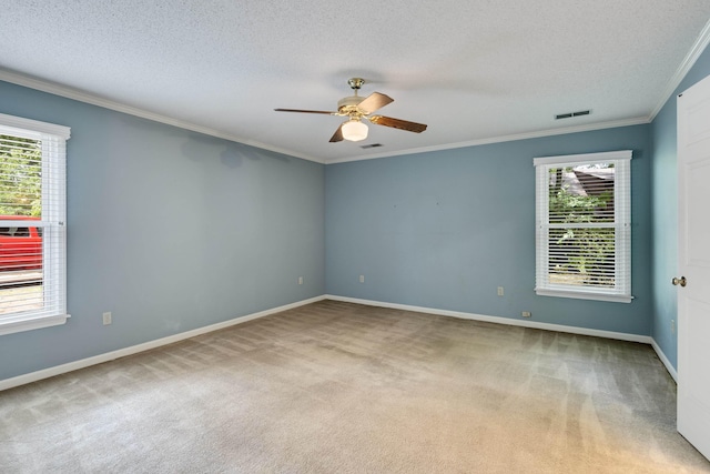 unfurnished room with carpet floors, plenty of natural light, a ceiling fan, crown molding, and a textured ceiling