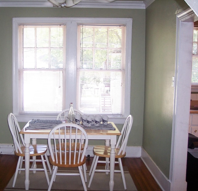 dining room with baseboards, crown molding, and dark wood-style floors
