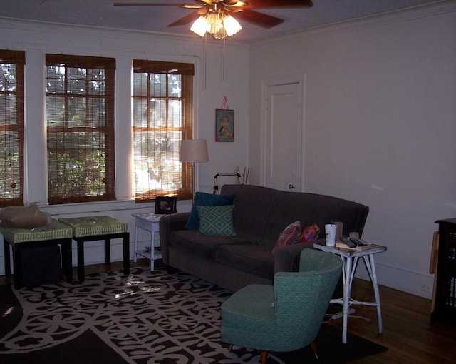 living area with ornamental molding, ceiling fan, and wood finished floors