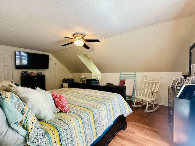 bedroom featuring wood finished floors, a textured ceiling, vaulted ceiling, a ceiling fan, and baseboards