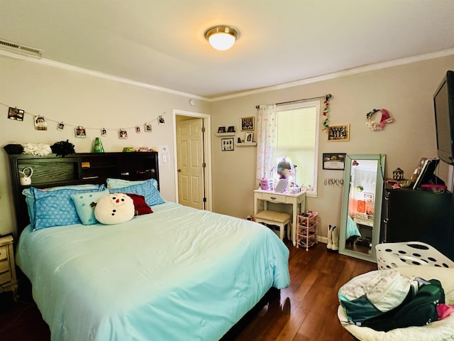 bedroom with crown molding, dark wood-type flooring, baseboards, and visible vents