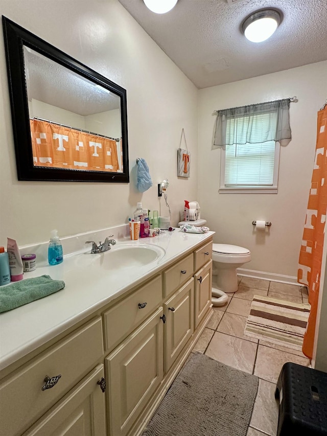 full bath featuring toilet, vanity, and a textured ceiling