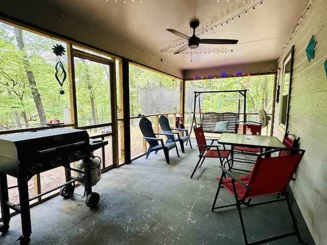 sunroom / solarium featuring outdoor dining area and ceiling fan