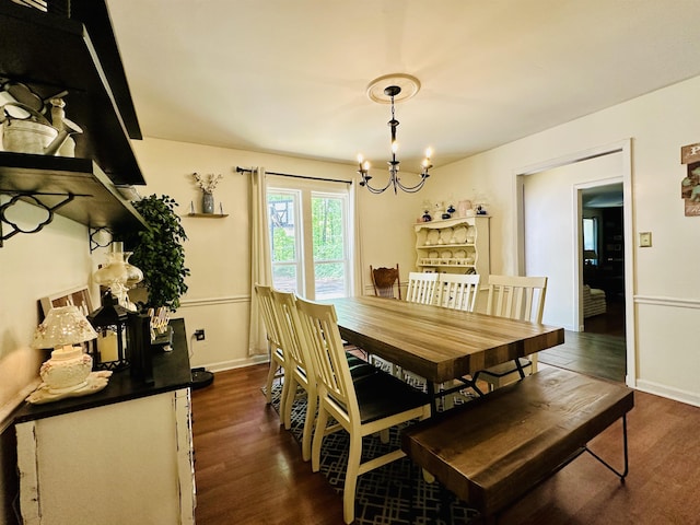 dining area with an inviting chandelier, baseboards, and dark wood-style floors