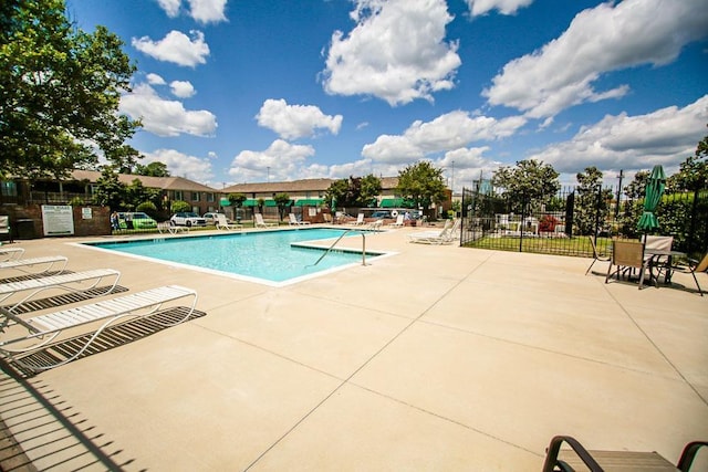 pool with a patio and fence