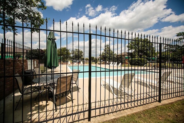 pool with a patio area and fence