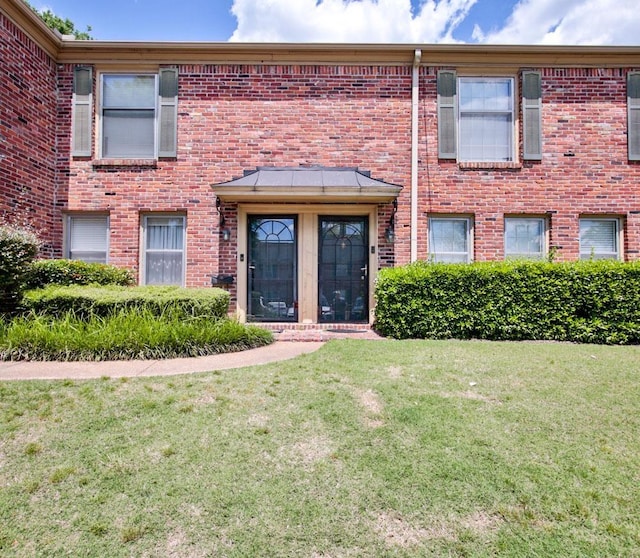 view of front of house with a front yard and brick siding