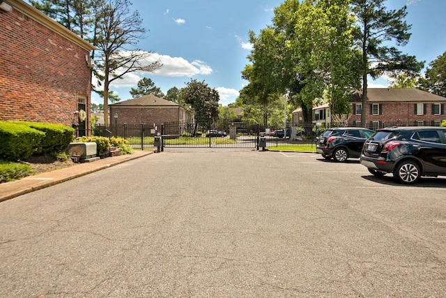 view of street with a gate, curbs, and a gated entry