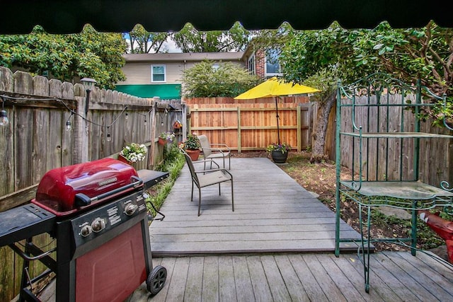 wooden deck featuring a fenced backyard and area for grilling