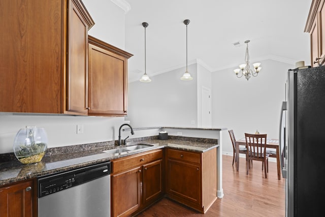 kitchen featuring a peninsula, crown molding, stainless steel appliances, and a sink
