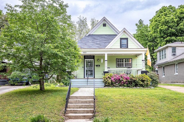 1851 Walker Ave, Memphis, TN 38114 - view of front of home with covered porch, a shingled roof, and a front yard