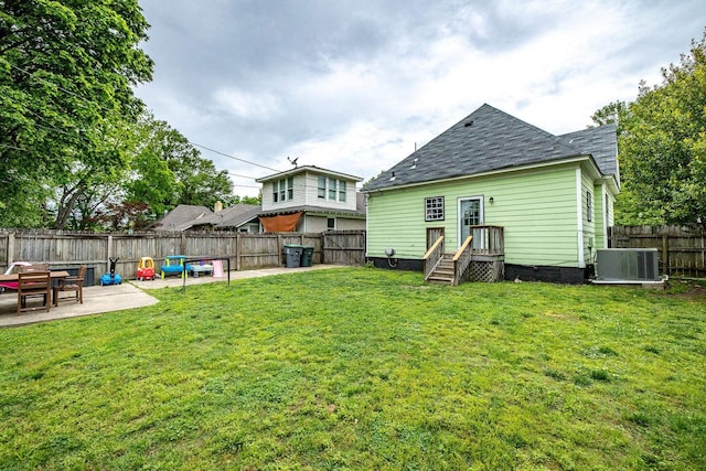 1851 Walker Ave, Memphis, TN 38114 - back of house with a patio, cooling unit, a lawn, a fenced backyard, and roof with shingles