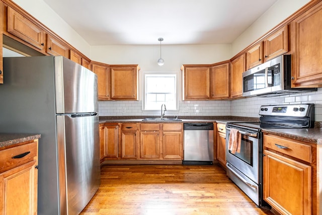 1851 Walker Ave, Memphis, TN 38114 - kitchen featuring a sink, brown cabinets, dark countertops, and appliances with stainless steel finishes