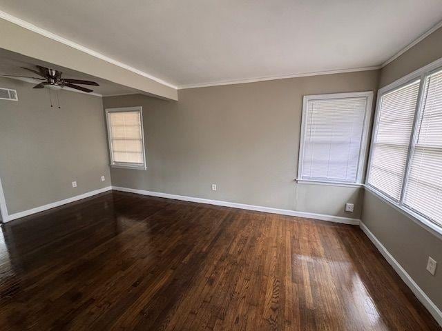 spare room featuring dark wood-type flooring, baseboards, a ceiling fan, and a healthy amount of sunlight