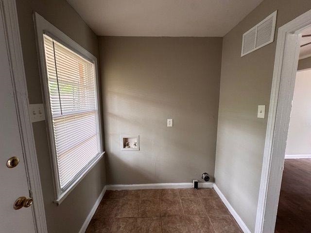 laundry area featuring baseboards, visible vents, washer hookup, dark tile patterned floors, and laundry area