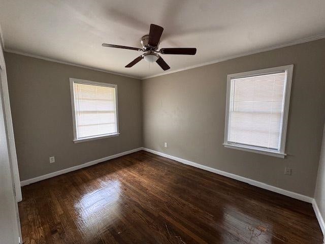 unfurnished room featuring ceiling fan, ornamental molding, baseboards, and wood finished floors