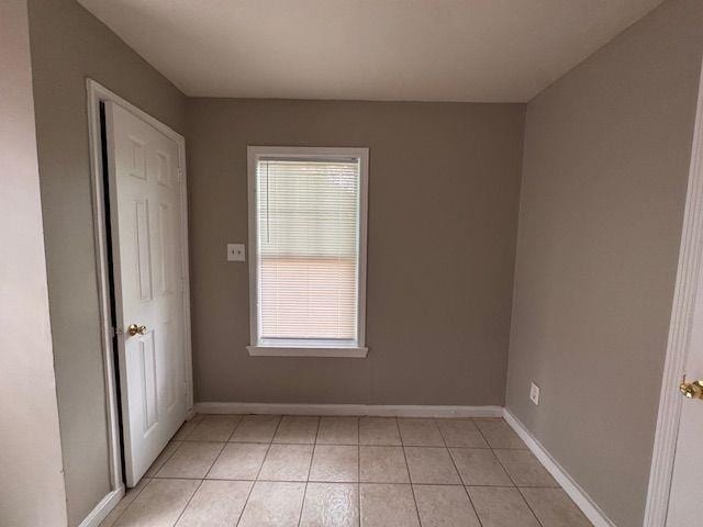unfurnished bedroom featuring light tile patterned floors and baseboards