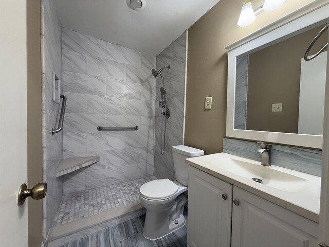 full bath with vanity, toilet, and tiled shower