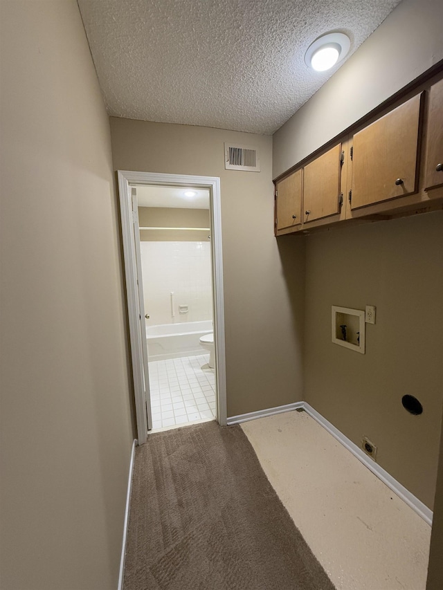 laundry room with cabinet space, a textured ceiling, visible vents, light carpet, and hookup for a washing machine