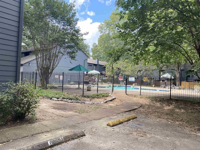 exterior space featuring fence and a community pool