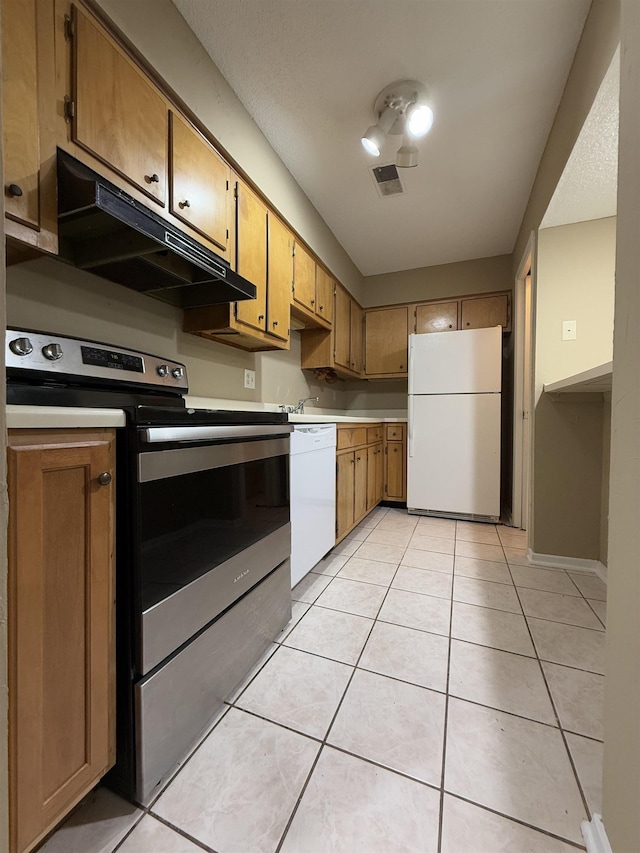 kitchen featuring white appliances, light countertops, light tile patterned flooring, and under cabinet range hood
