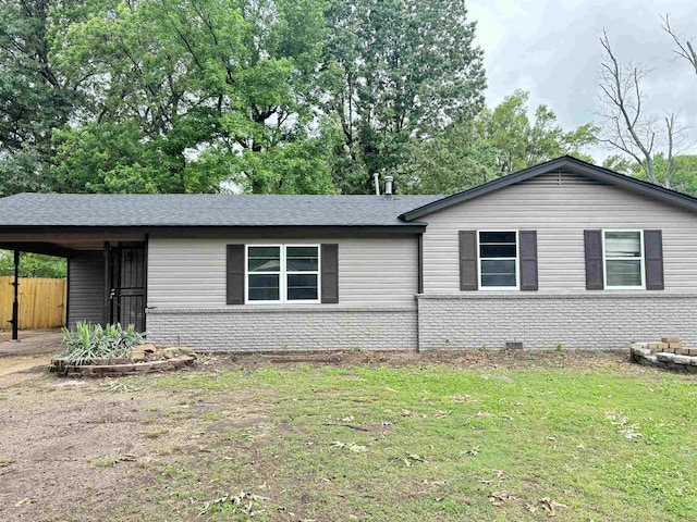 ranch-style house featuring fence, a front yard, brick siding, and an attached carport