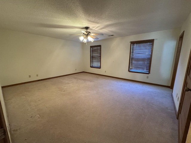 empty room with ceiling fan, light carpet, and baseboards