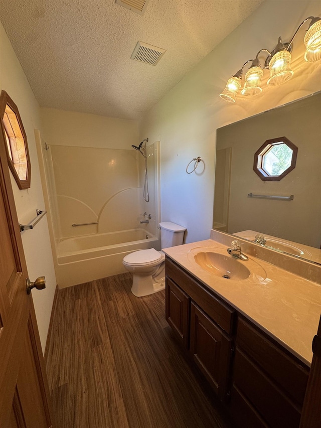 bathroom with toilet, wood finished floors, a textured ceiling, visible vents, and shower / bath combination
