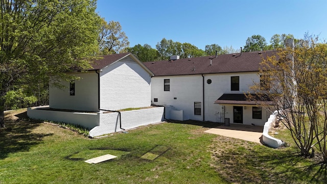 back of property featuring a yard and a patio area