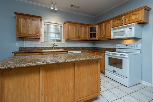 kitchen featuring white appliances, tasteful backsplash, visible vents, and a sink