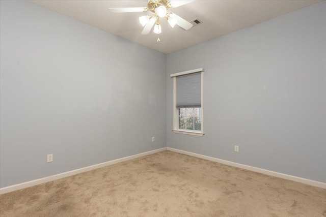 spare room featuring ceiling fan, light carpet, baseboards, and visible vents