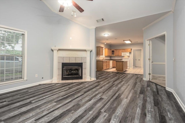 unfurnished living room with visible vents, wood finished floors, a ceiling fan, and ornamental molding