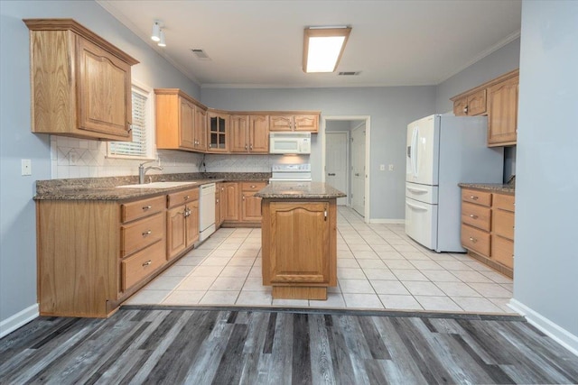 kitchen with a sink, white appliances, visible vents, crown molding, and a kitchen island