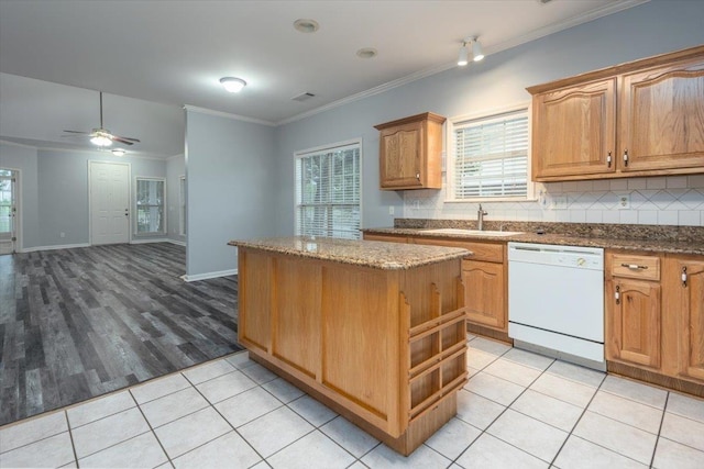 kitchen featuring a wealth of natural light, a center island, a sink, and white dishwasher