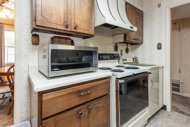 5676 Quince Rd Unit 7, Memphis, TN 38119 - kitchen with custom exhaust hood, brown cabinetry, wallpapered walls, and electric range