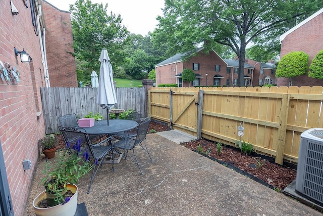 5676 Quince Rd Unit 7, Memphis, TN 38119 - view of patio / terrace featuring central AC unit, outdoor dining area, a fenced backyard, and a gate