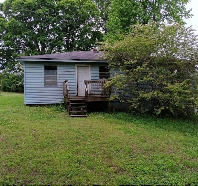 rear view of property with a lawn and a wooden deck