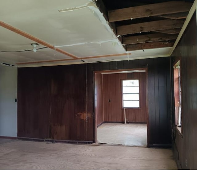 unfurnished room featuring wooden walls