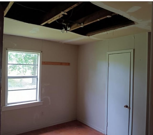unfurnished room with baseboards