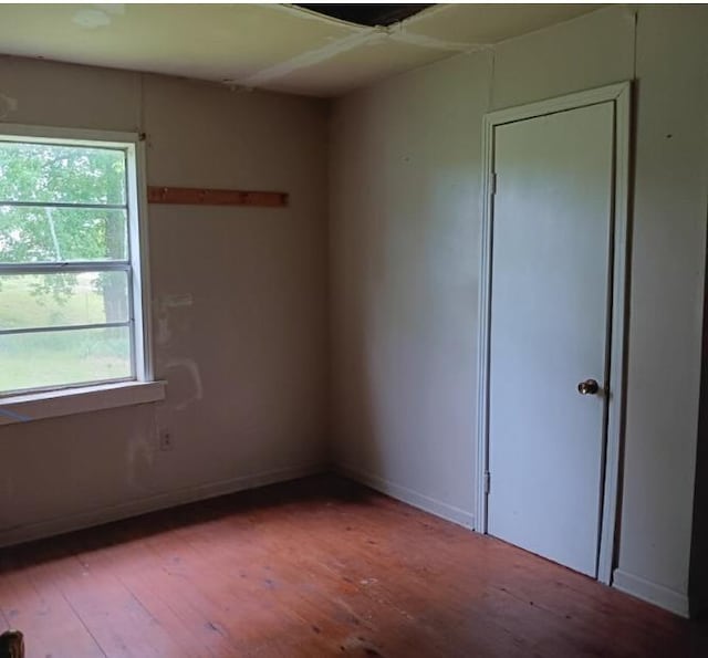 empty room featuring baseboards and hardwood / wood-style floors
