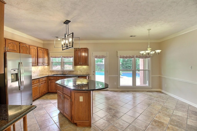 1599 John Ridge Dr, Collierville, TN 38017 - kitchen featuring a chandelier, stainless steel fridge, a sink, brown cabinets, and a textured ceiling